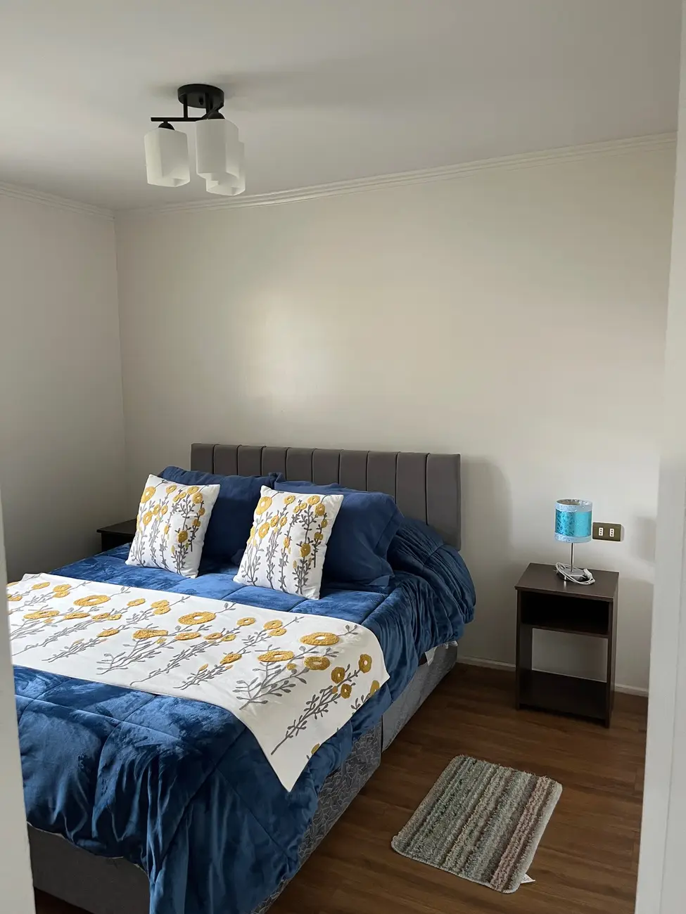 Dormitorio cálido con ropa de cama azul y mostaza